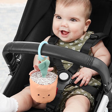baby in stroller with GARDEN OASIS toy